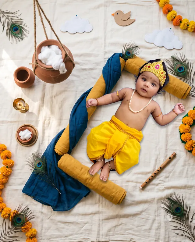 Baby Krishna lying beside a hanging butter pot within a blue and yellow fabric frame