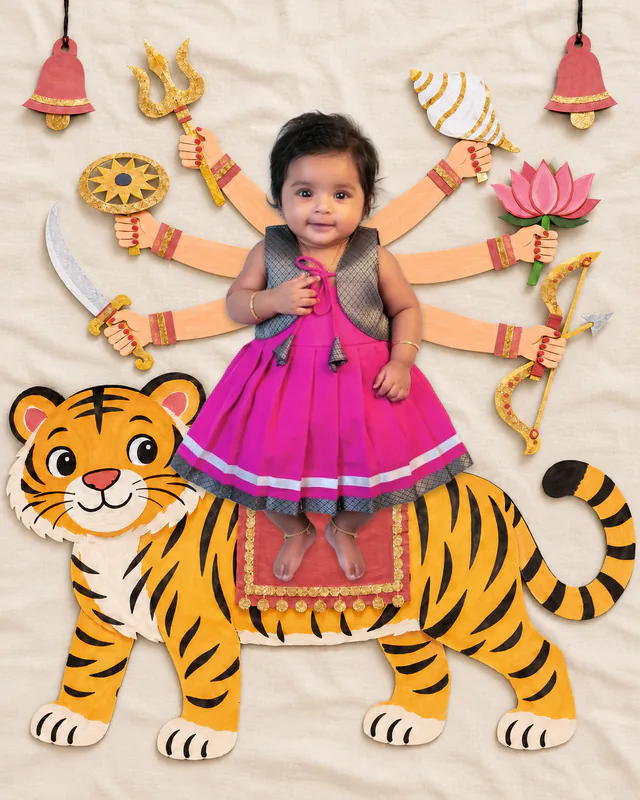 Baby in a Sherawali Mata scene with a smiling tiger, illustrated goddess arms, lotus and hanging bells