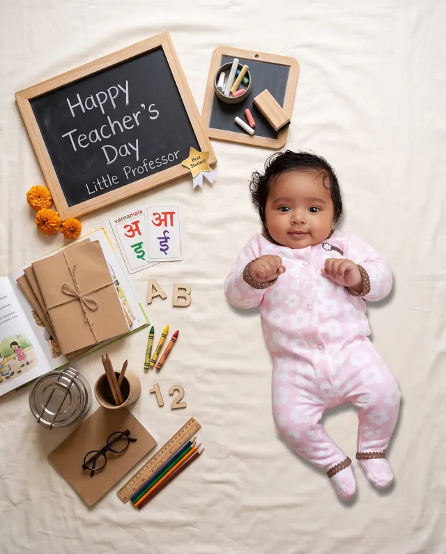 Baby little professor beside chalkboards, alphabet cards, books and coloured pencils